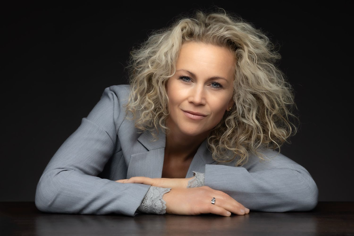 Professional studio portraits with dramatic lighting against a dark background.