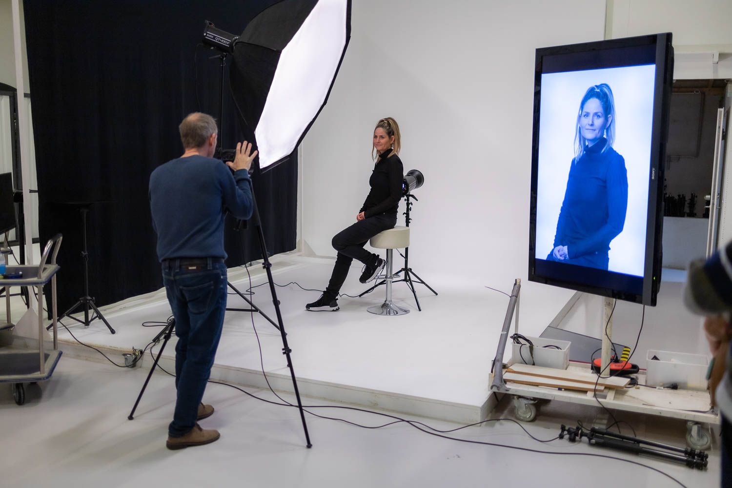 Professional photography studio setup with lighting equipment and white backdrop.