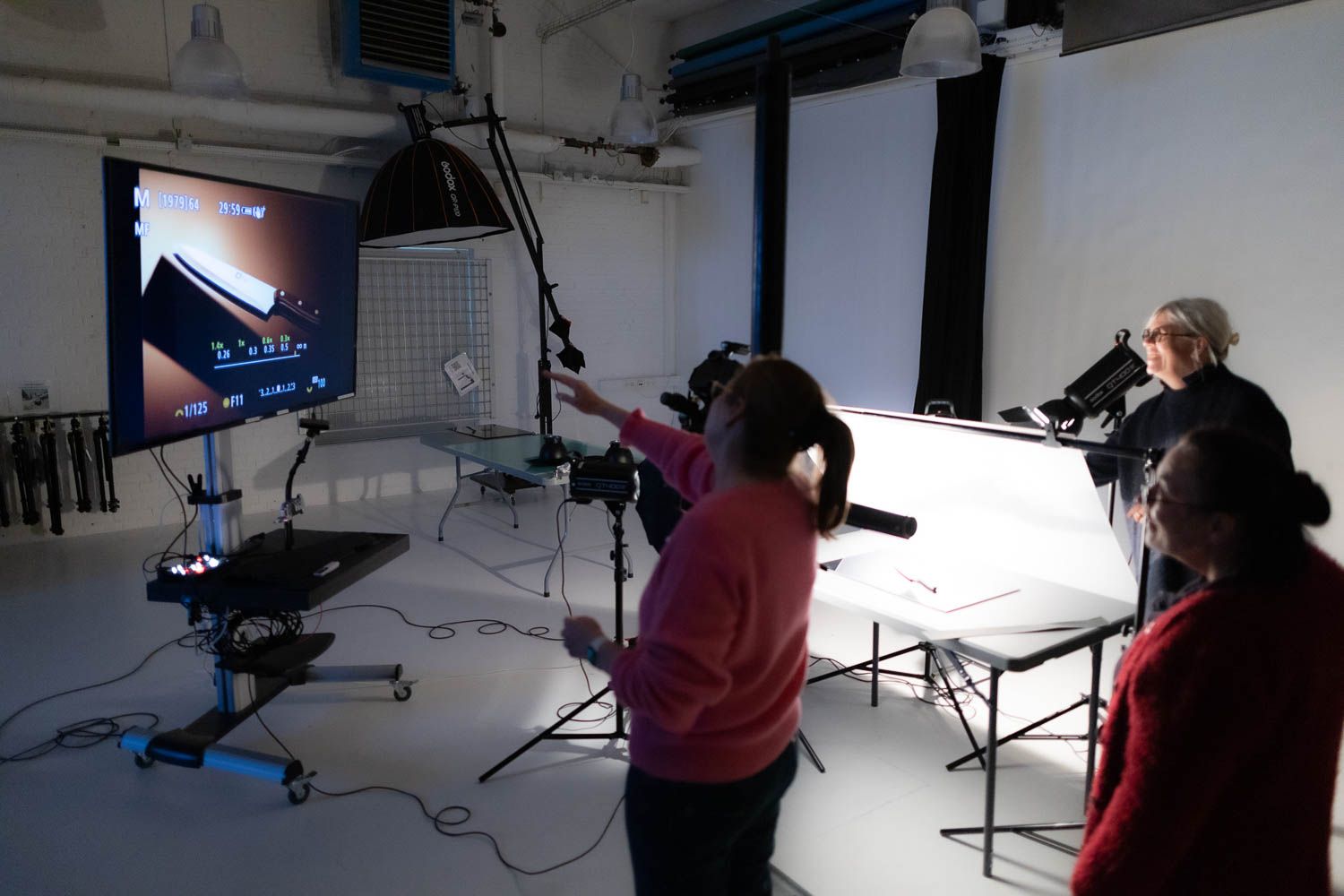 Photography studio setup showing various lighting equipment and camera gear.