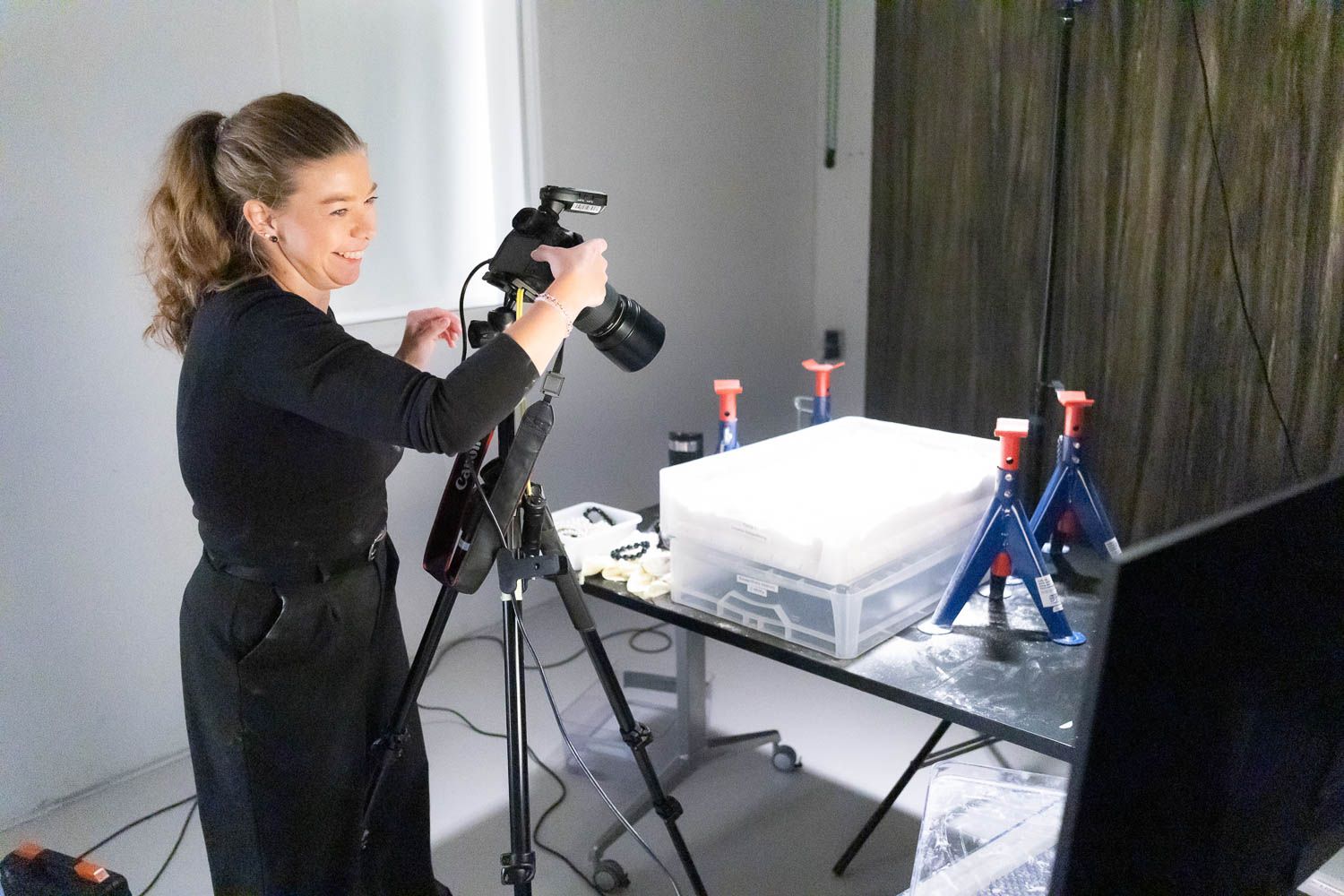 Photographers working with professional equipment in bright modern studio space.