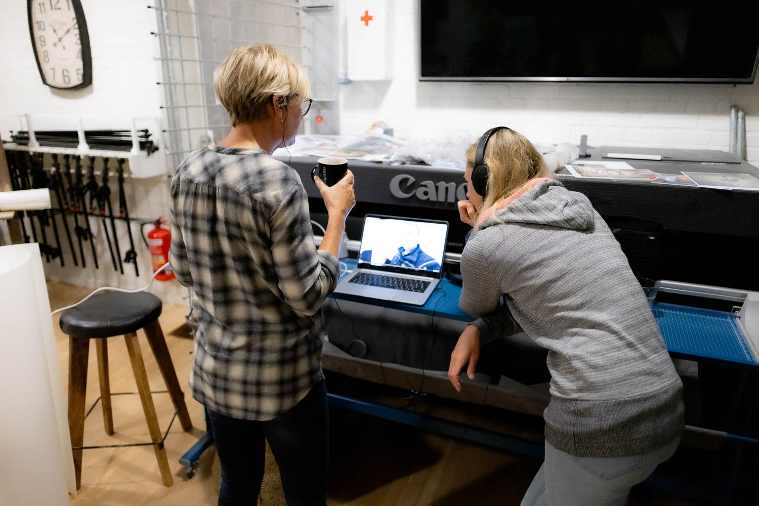 People working at computer stations in a production studio environment.