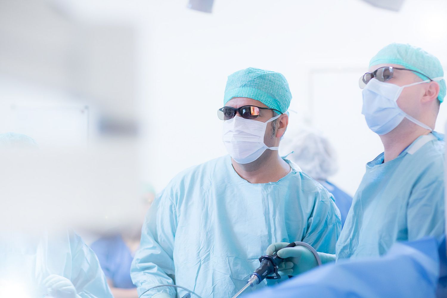 Surgical team performing operation in sterile environment with medical equipment.