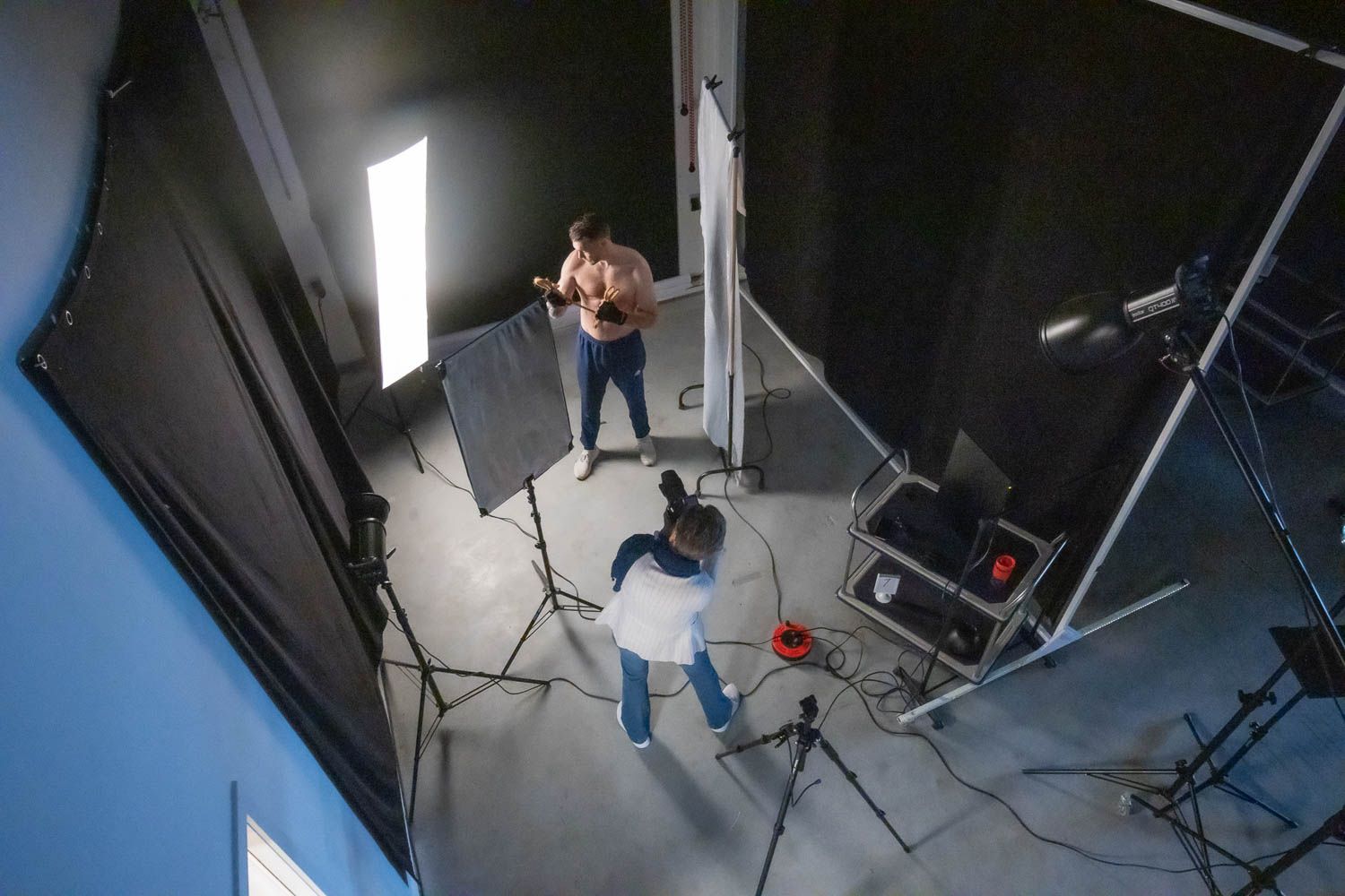 Studio lighting equipment arranged in a professional photography space with white backdrop.