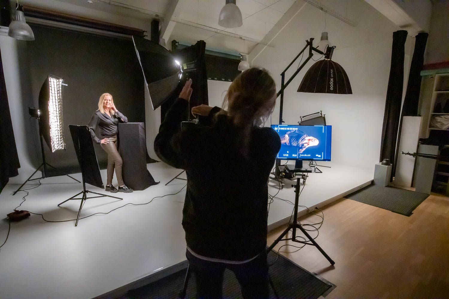 Professional photography studio interior with lighting equipment and white backdrop setup.