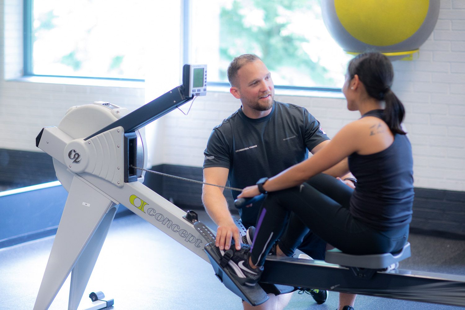 Workout demonstration taking place in bright fitness studio with yellow exercise balls.