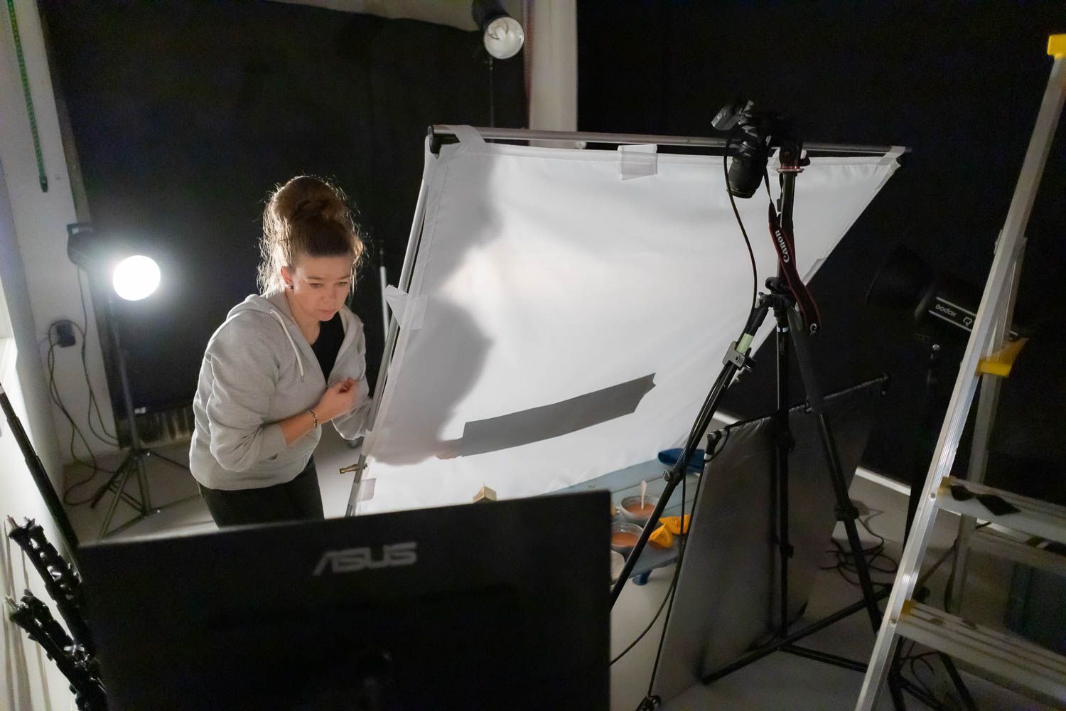 Photography studio setup showing softboxes and lighting equipment arranged around white backdrop.