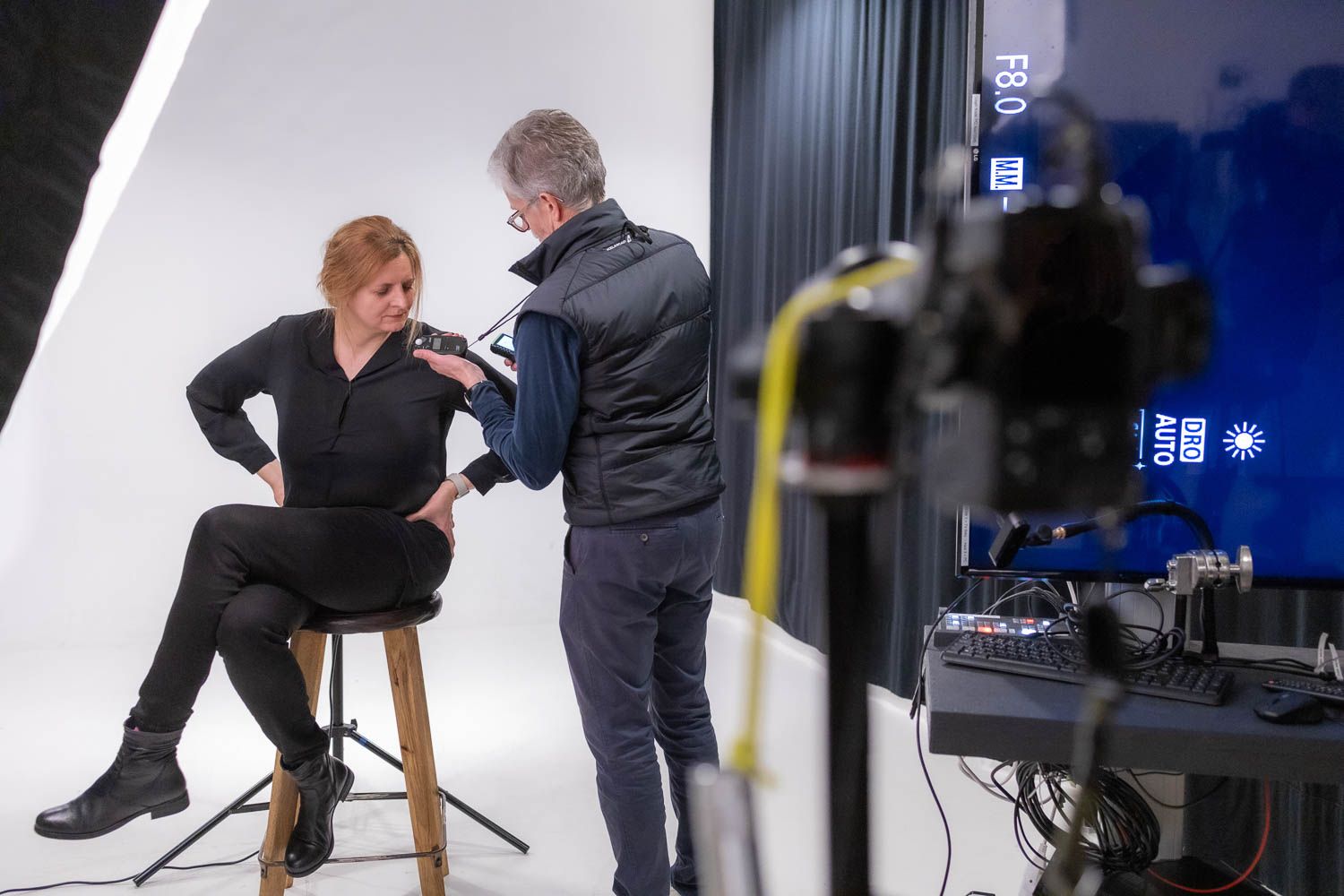 Professional photo shoot in progress on white backdrop with studio lighting setup.