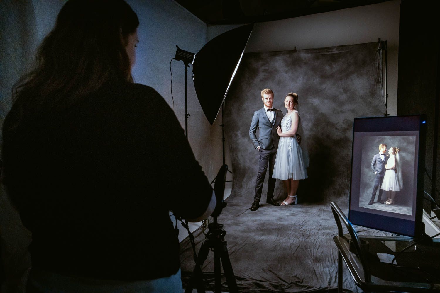 Dark studio environment with dramatic lighting setup and professional photography equipment.