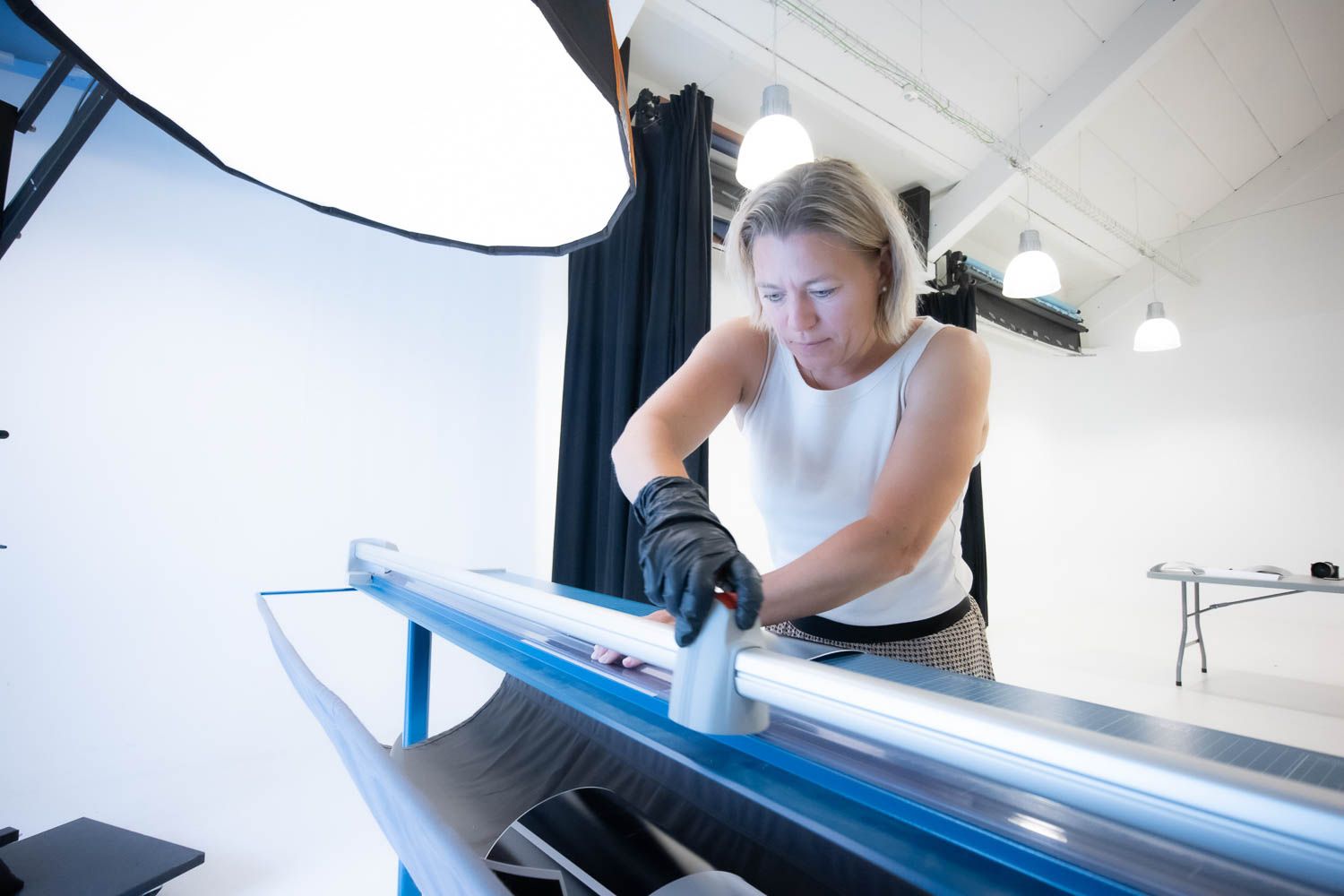 Person organizing prints on a large light table in photography studio.