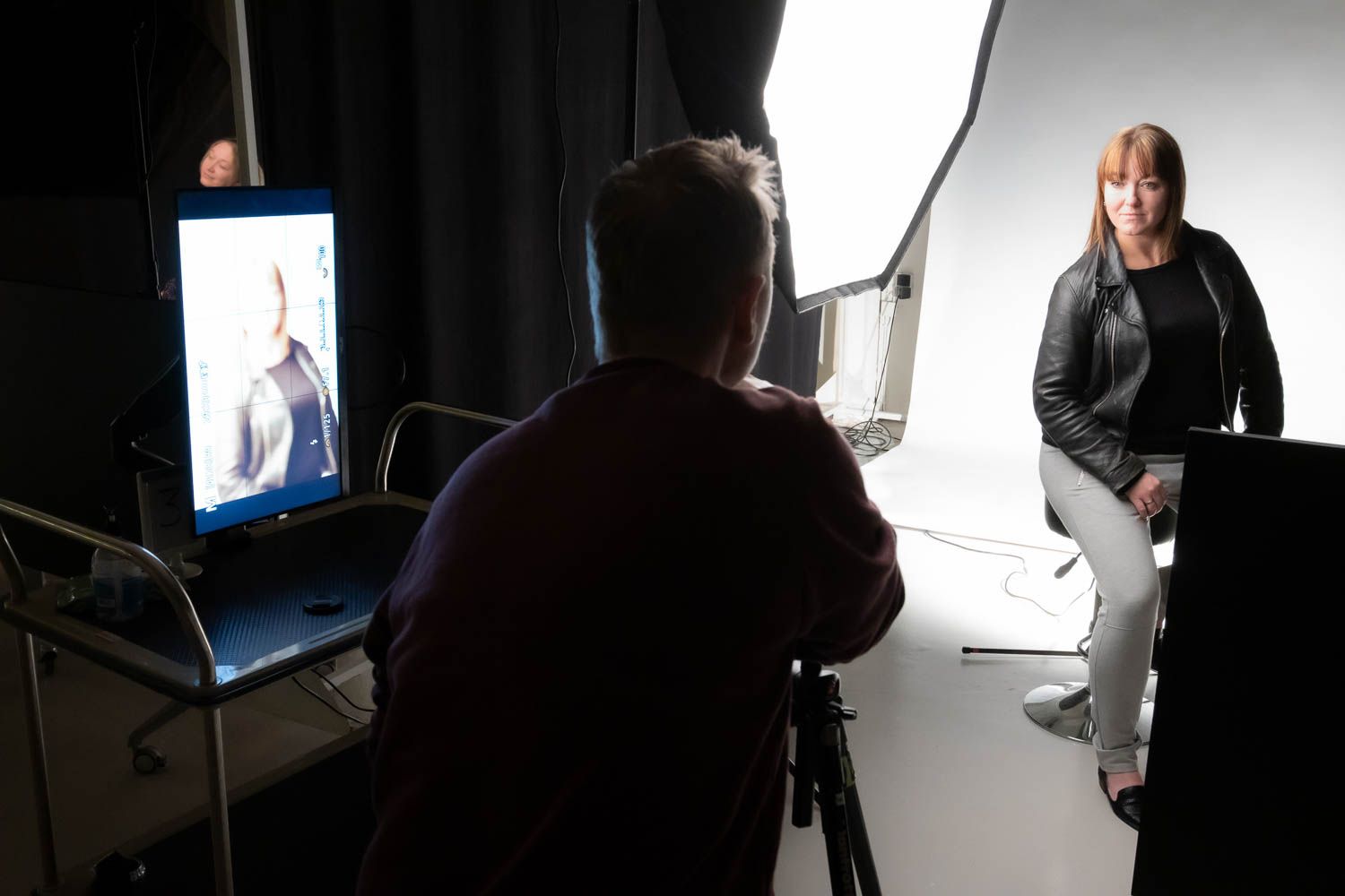 Professional photography studio setup showing lighting equipment and backdrop preparation.