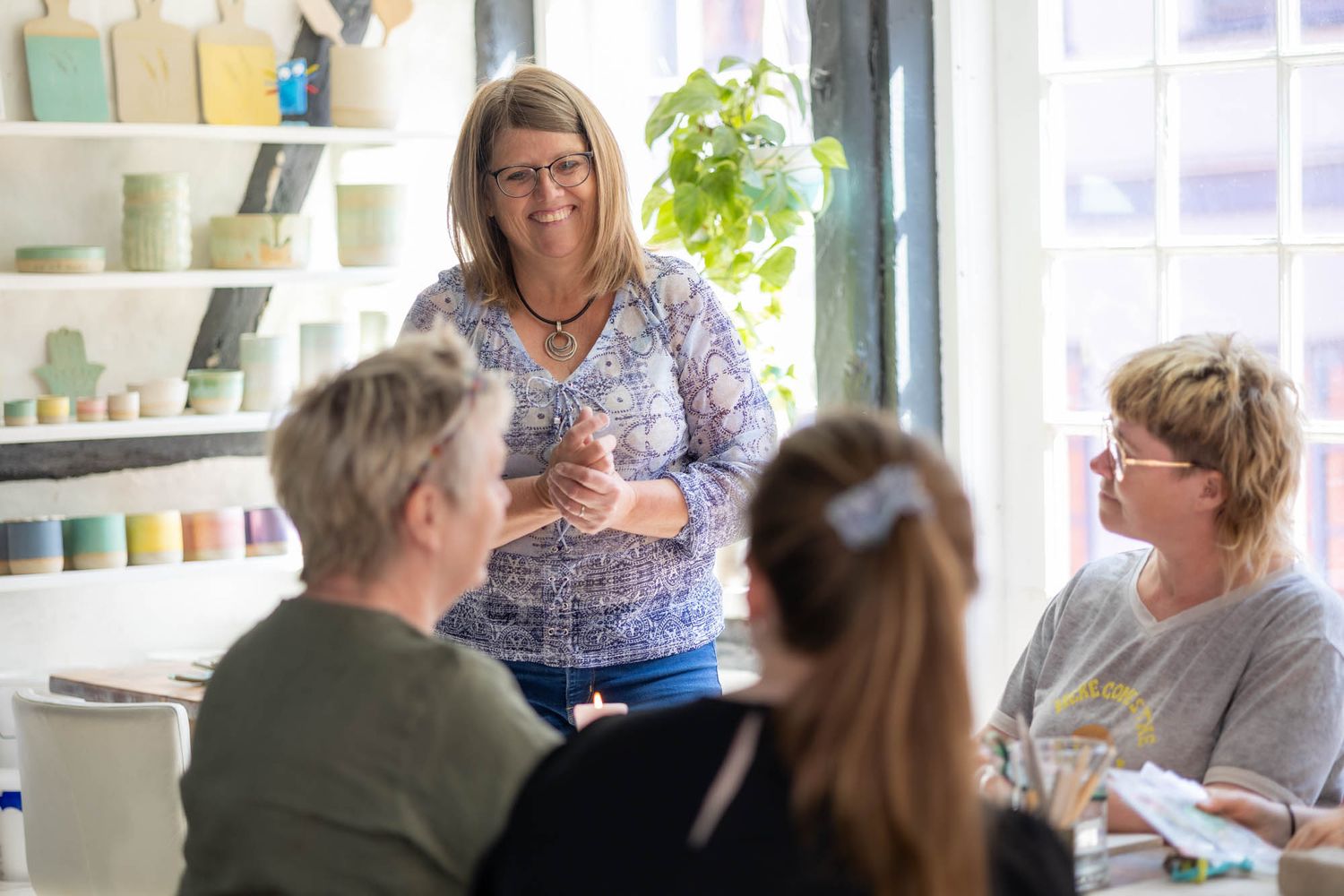 People engaged in discussion during a creative workshop in an art studio setting.