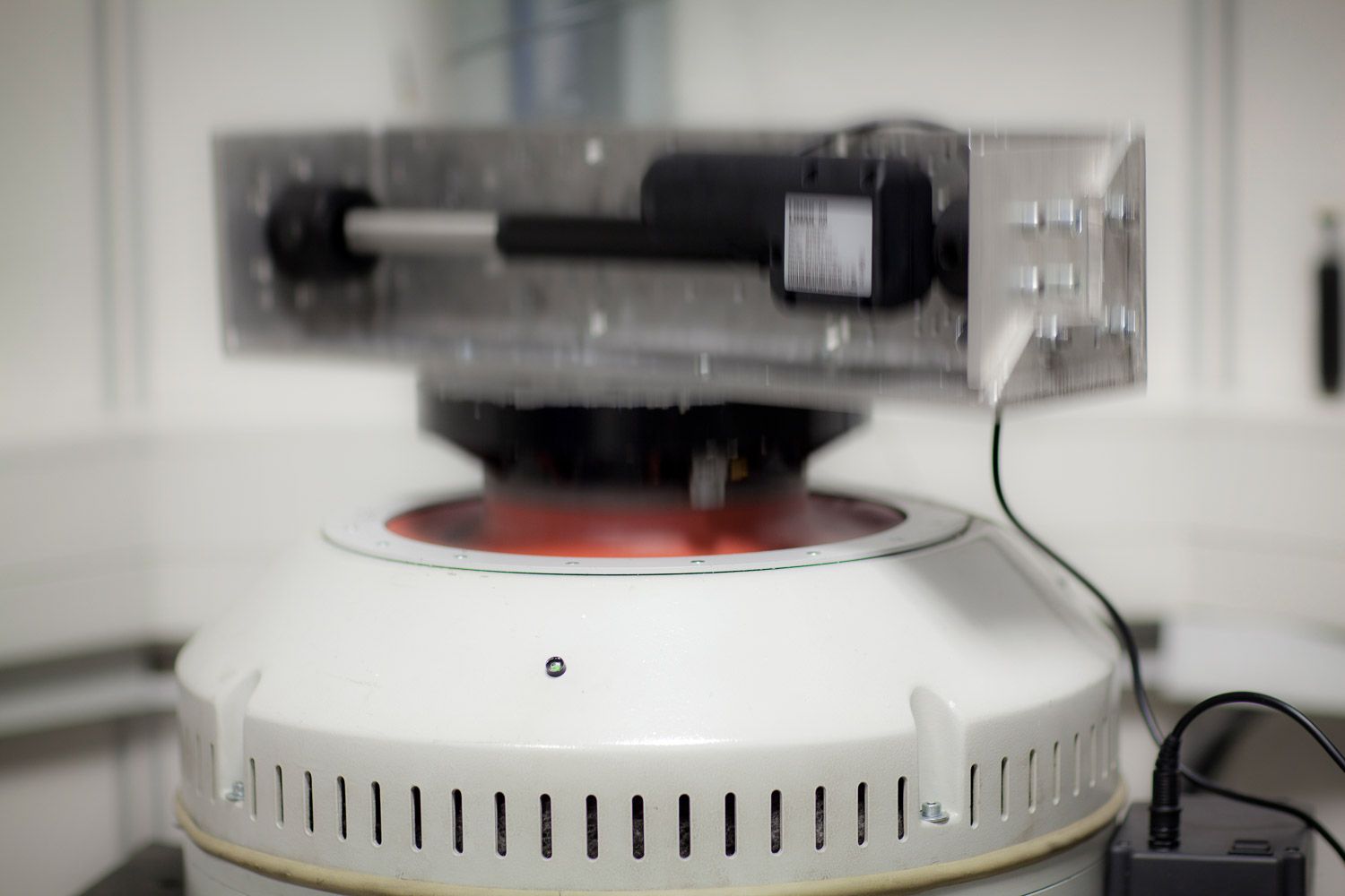 Close-up view of circular testing equipment components in white laboratory setting.