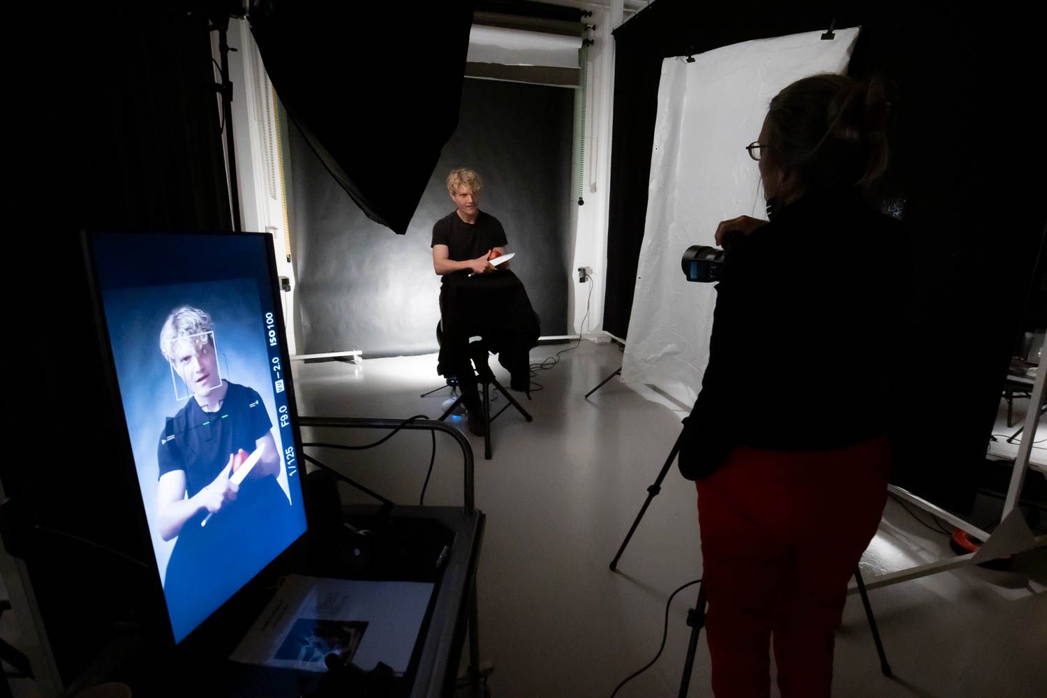 Dark studio with blue screen display and professional lighting setup.