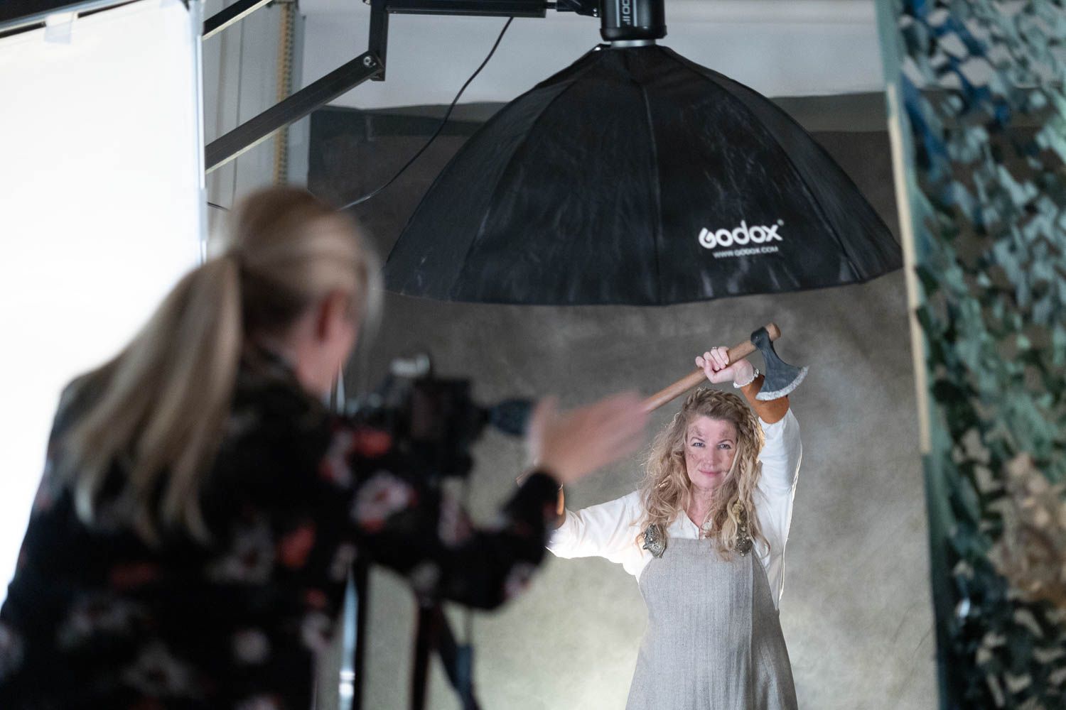 Studio photography session with softbox lighting and white dress under black umbrella.