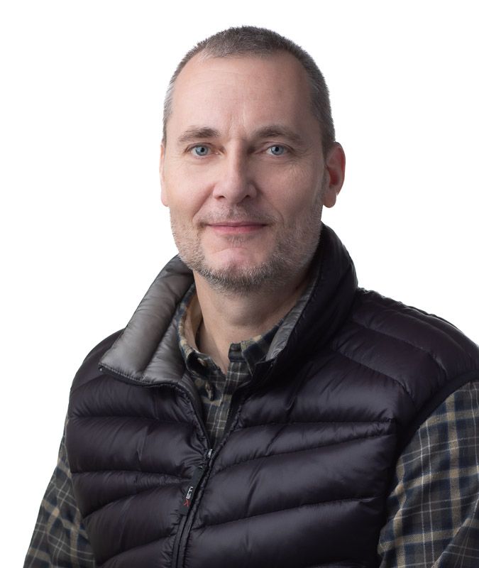 Person wearing black puffer vest and plaid shirt shown in multiple profile views against white background.