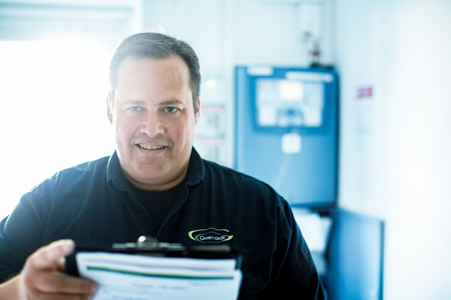 Professional technician examining equipment readings in bright facility.
