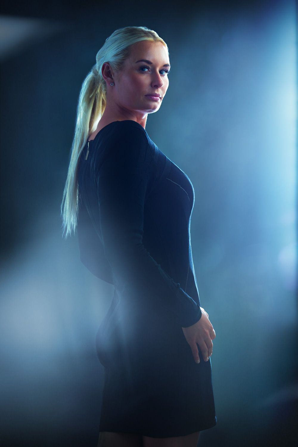 Dramatic profile portraits of blonde subject in black blazer with blue backlight.