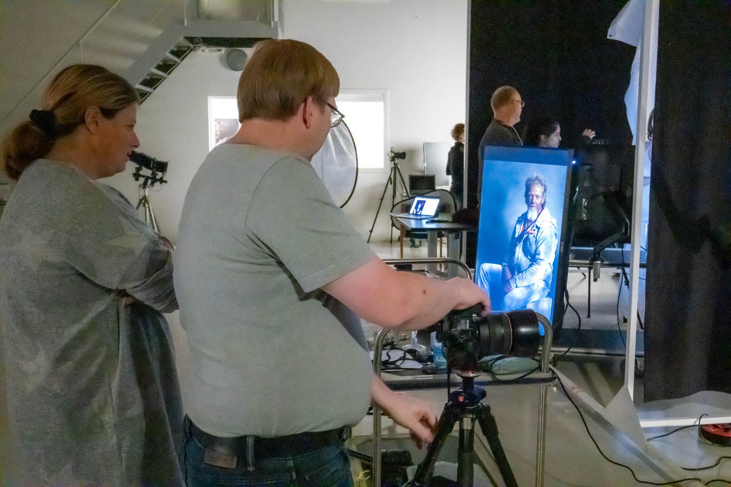 Behind the scenes view of a professional photo studio setup with lighting equipment and monitors.