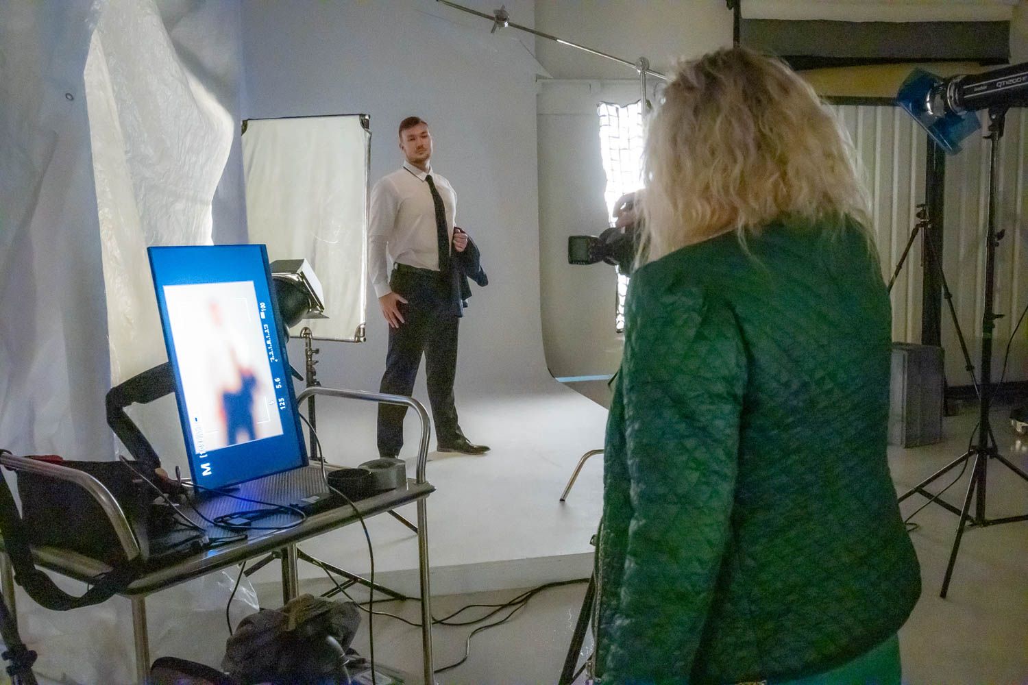 Behind-the-scenes studio photography setup with lighting equipment and monitors.