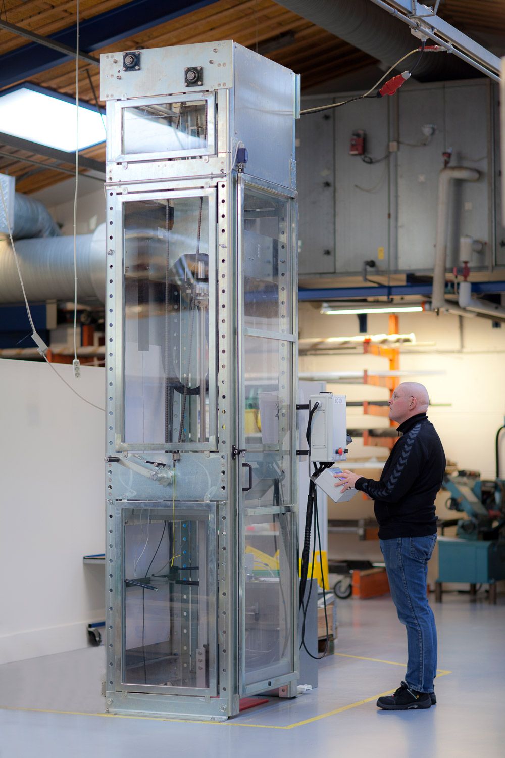 Industrial equipment setup showing transparent safety enclosures in a manufacturing facility.