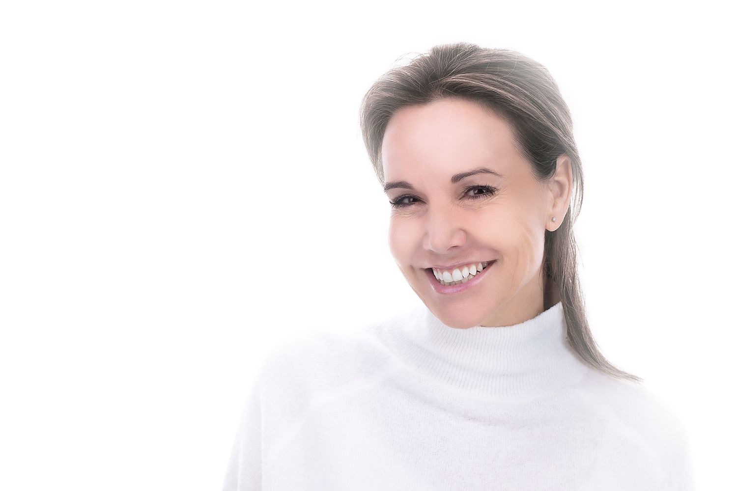 Cheerful person wearing white turtleneck in studio portrait setting.