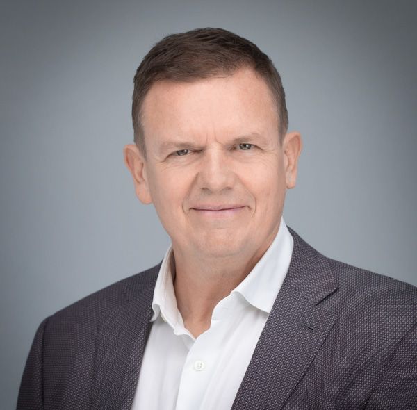 Professional headshot series showing a man in a grey suit jacket against a gradient background.