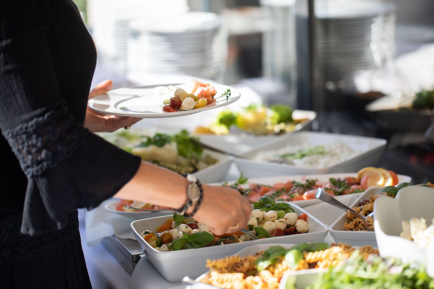 Fresh salads and appetizers being prepared at an outdoor catering station.