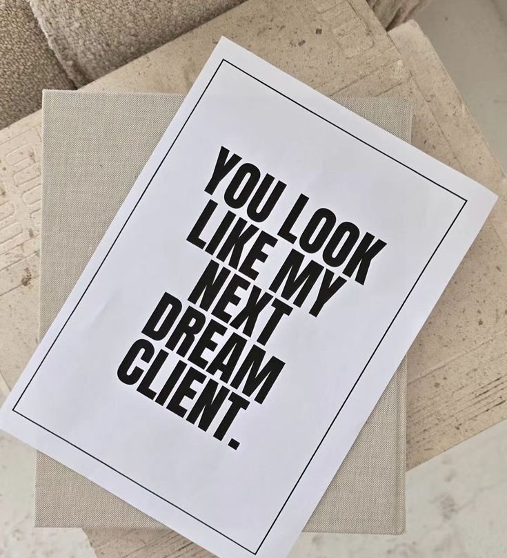 White print with bold black text reading YOU LOOK LIKE MY NEXT DREAM CLIENT, displayed on a neutral linen surface.