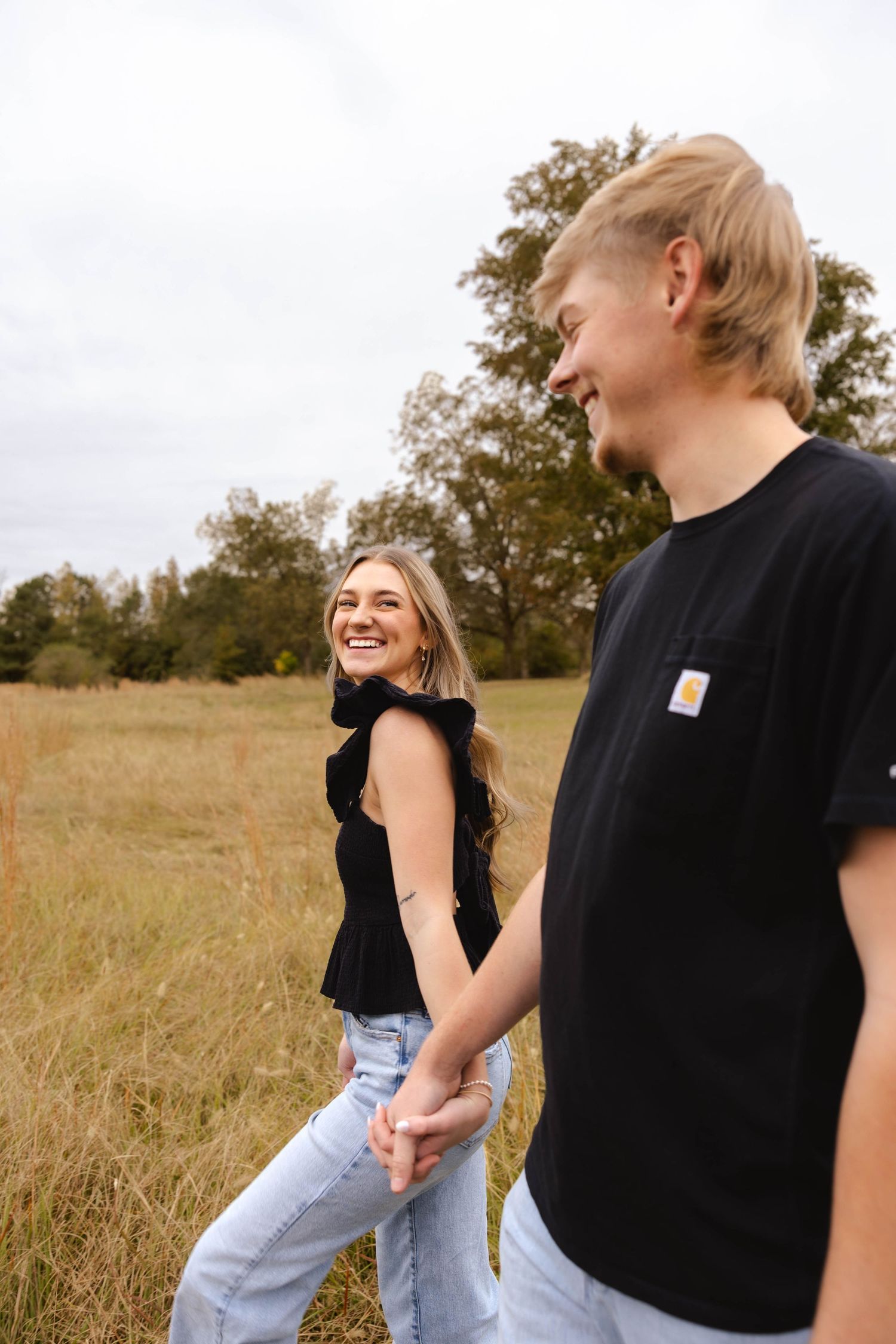 Candid moment of people laughing together in a golden autumn field.