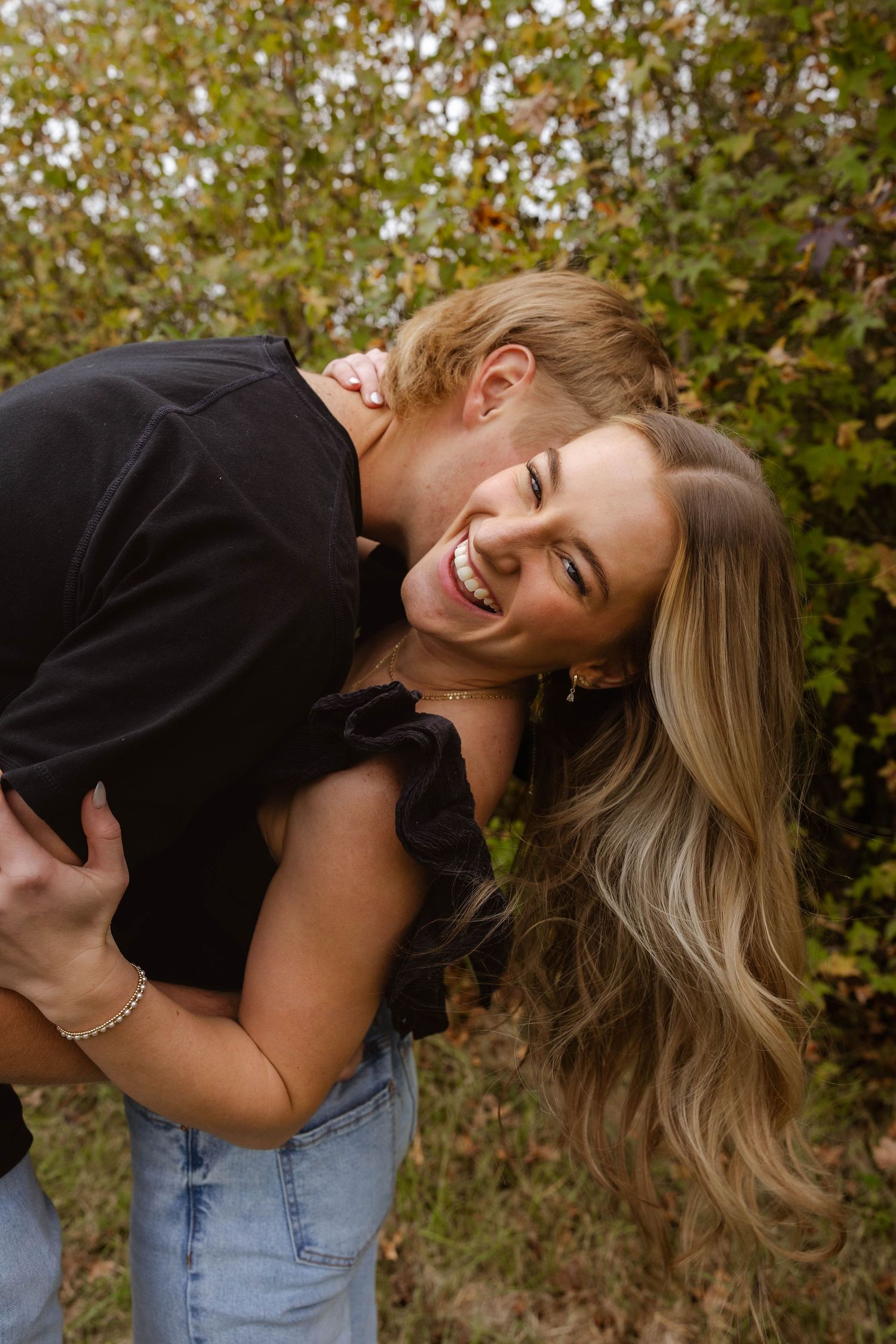 Candid laughing moments captured in outdoor portrait session.