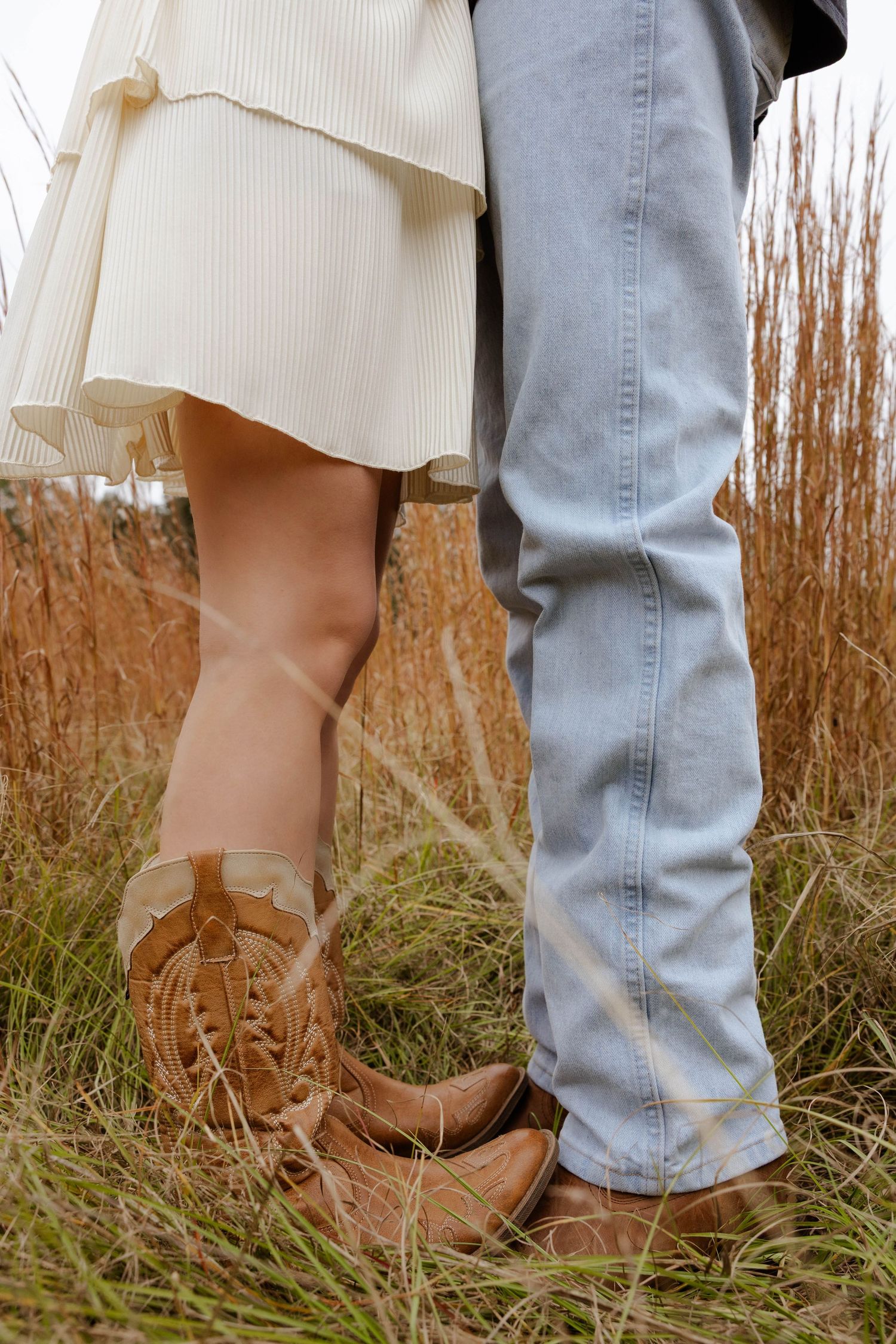 Close-up of boots standing together in tall autumn grass.
