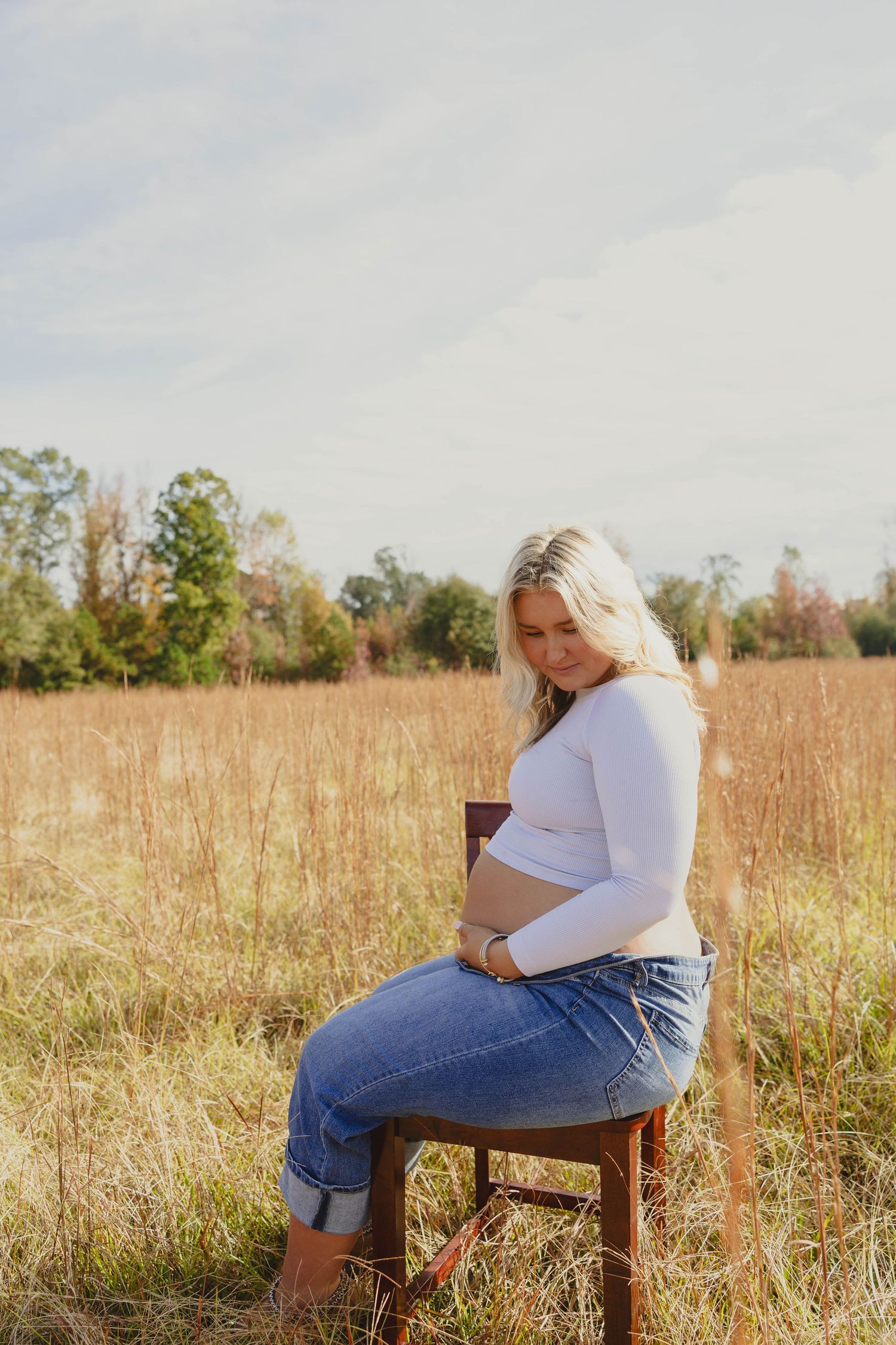 A series of outdoor portraits showing someone in a white shirt and jeans sitting on a wooden chair in a golden field.