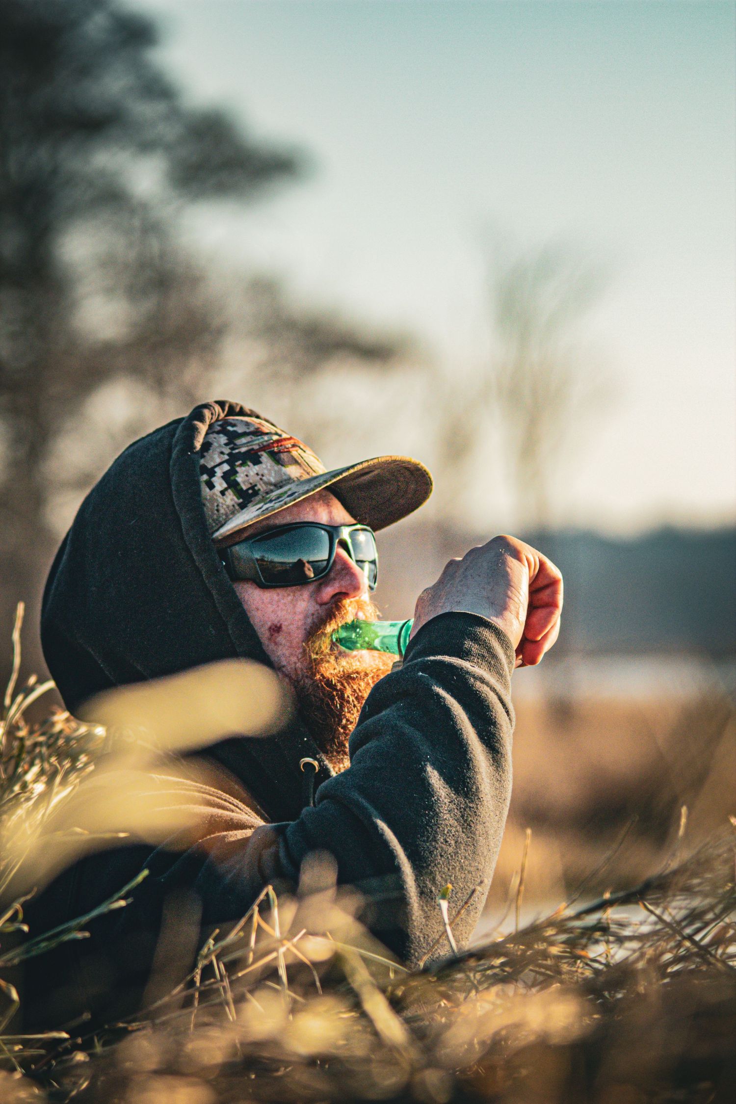 Duck hunters lying in wait among tall grass during an early morning hunt.