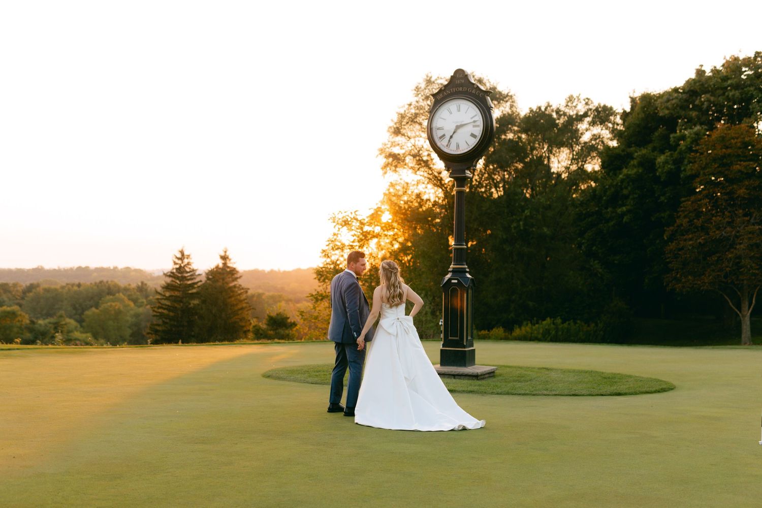 Elegant wedding portraits captured on a scenic golf course with golden sunset lighting.