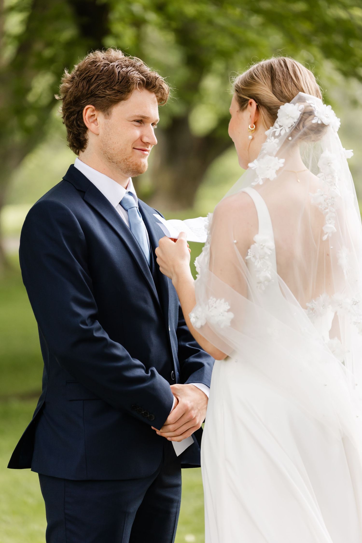 An intimate wedding ceremony moment with the couple exchanging vows outdoors.