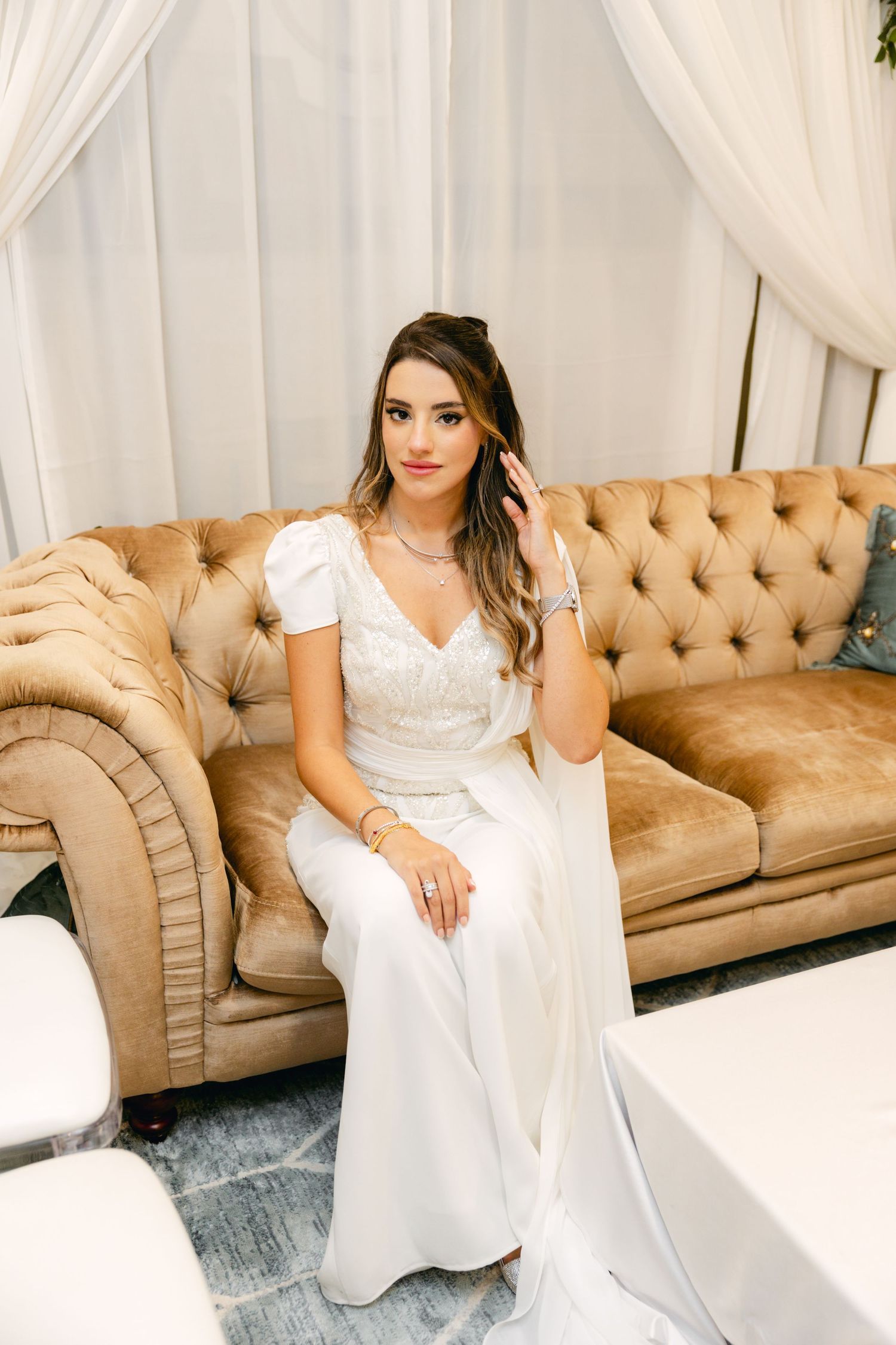 Wedding photography setup with vintage couch and white drapery backdrop.