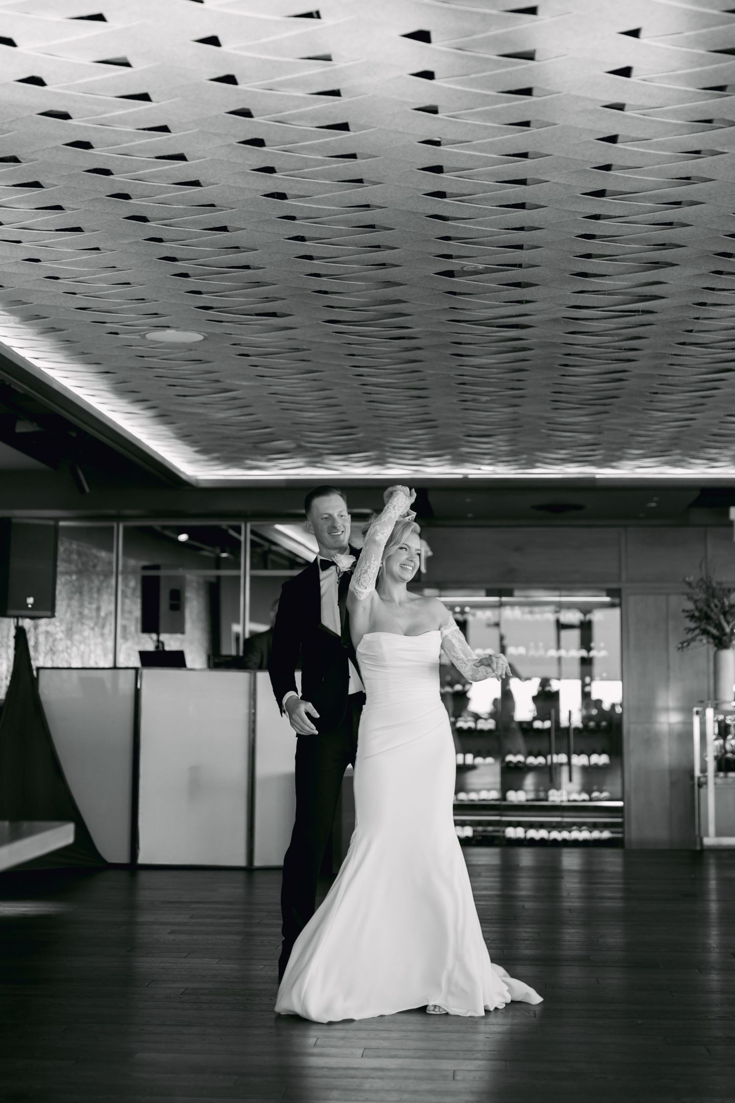 Bride and groom share their first dance in a black and white photo at an elegant wedding reception venue.