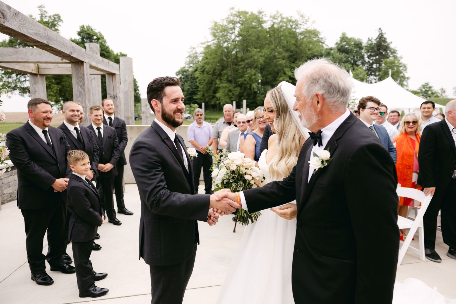 Wedding guests mingling and celebrating on outdoor stone patio.