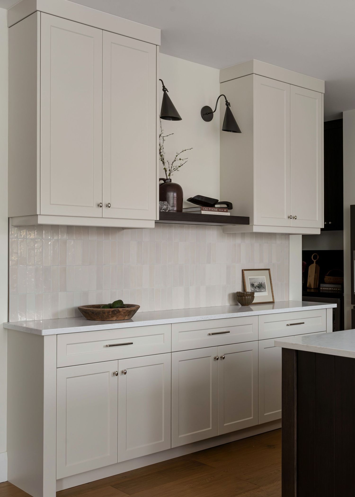 Long white kitchen with shaker cabinets and minimal modern design elements.