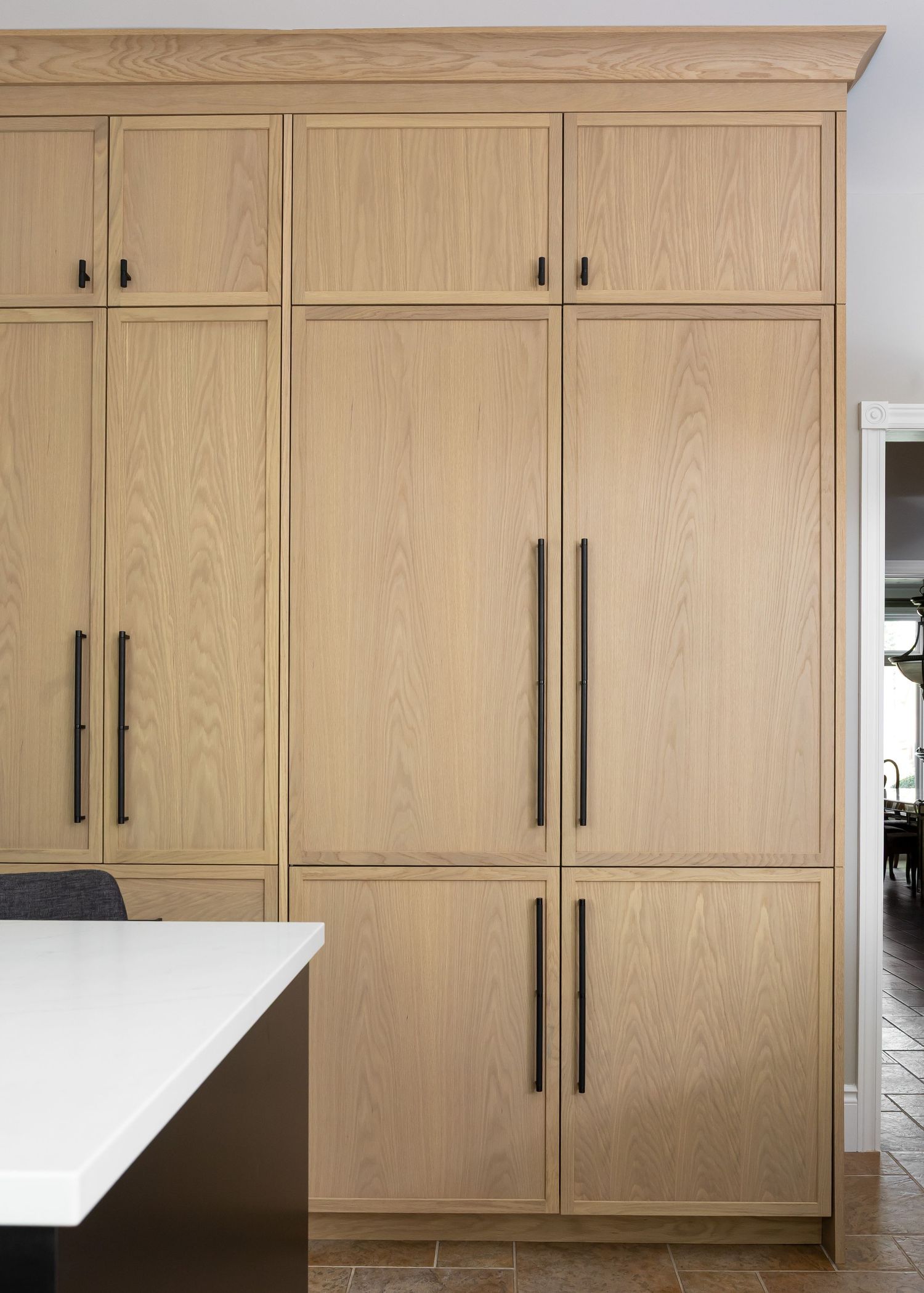 Custom built-in wood cabinets with black hardware extending from floor to ceiling.