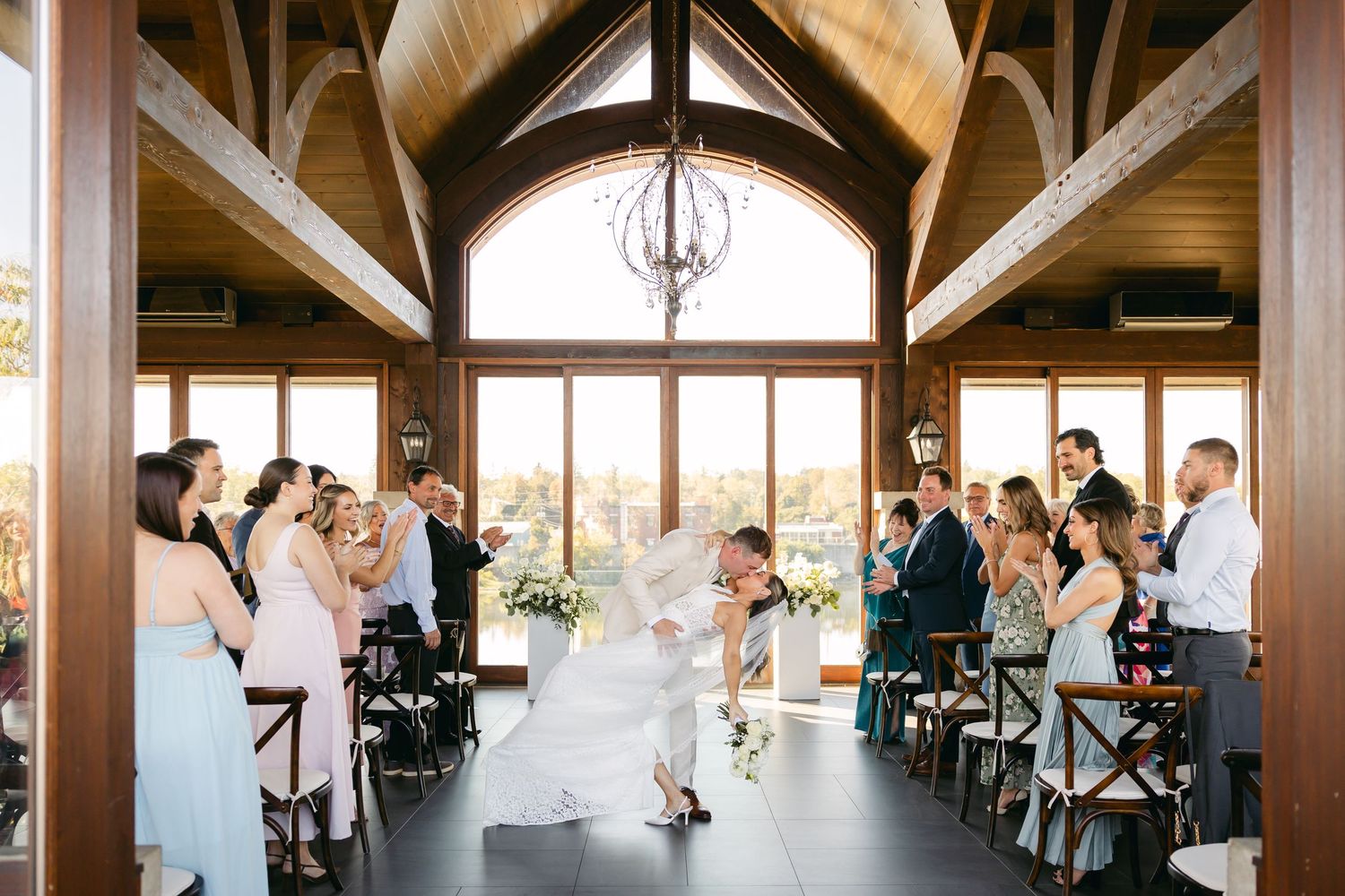 Panoramic view of wedding venue with wooden beams and natural lighting.