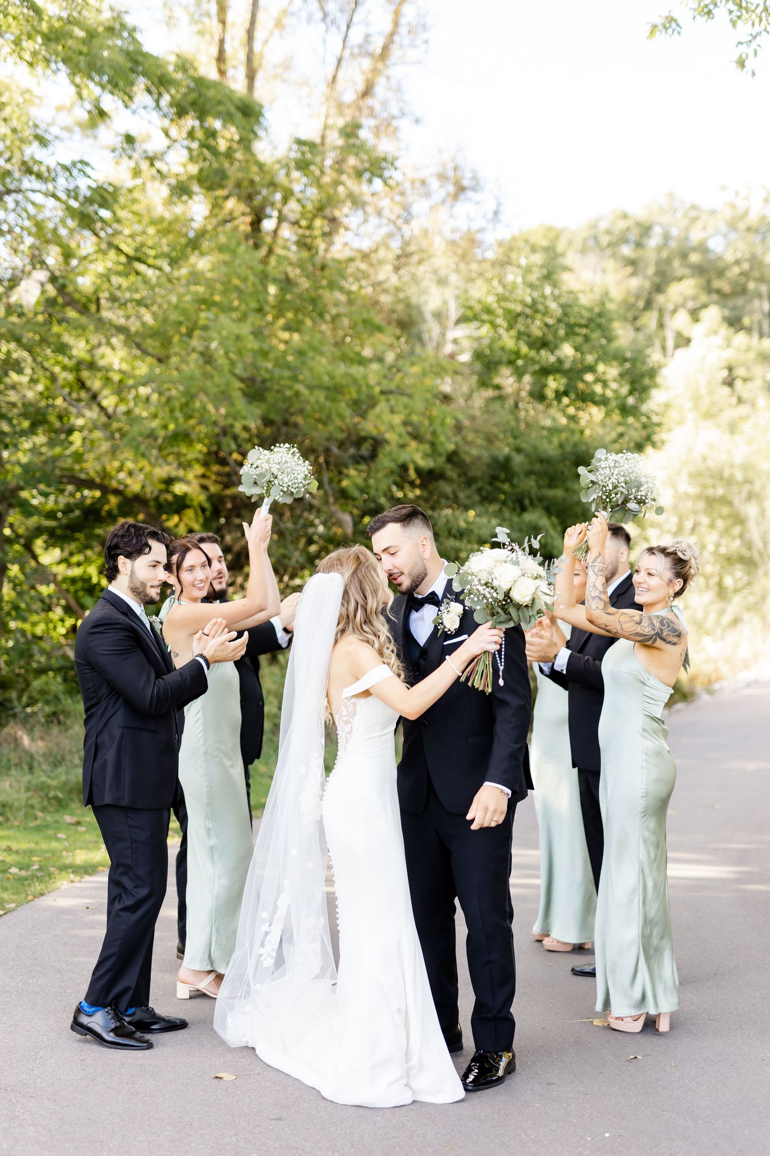 Wedding party dancing and celebrating together outdoors in formal attire.