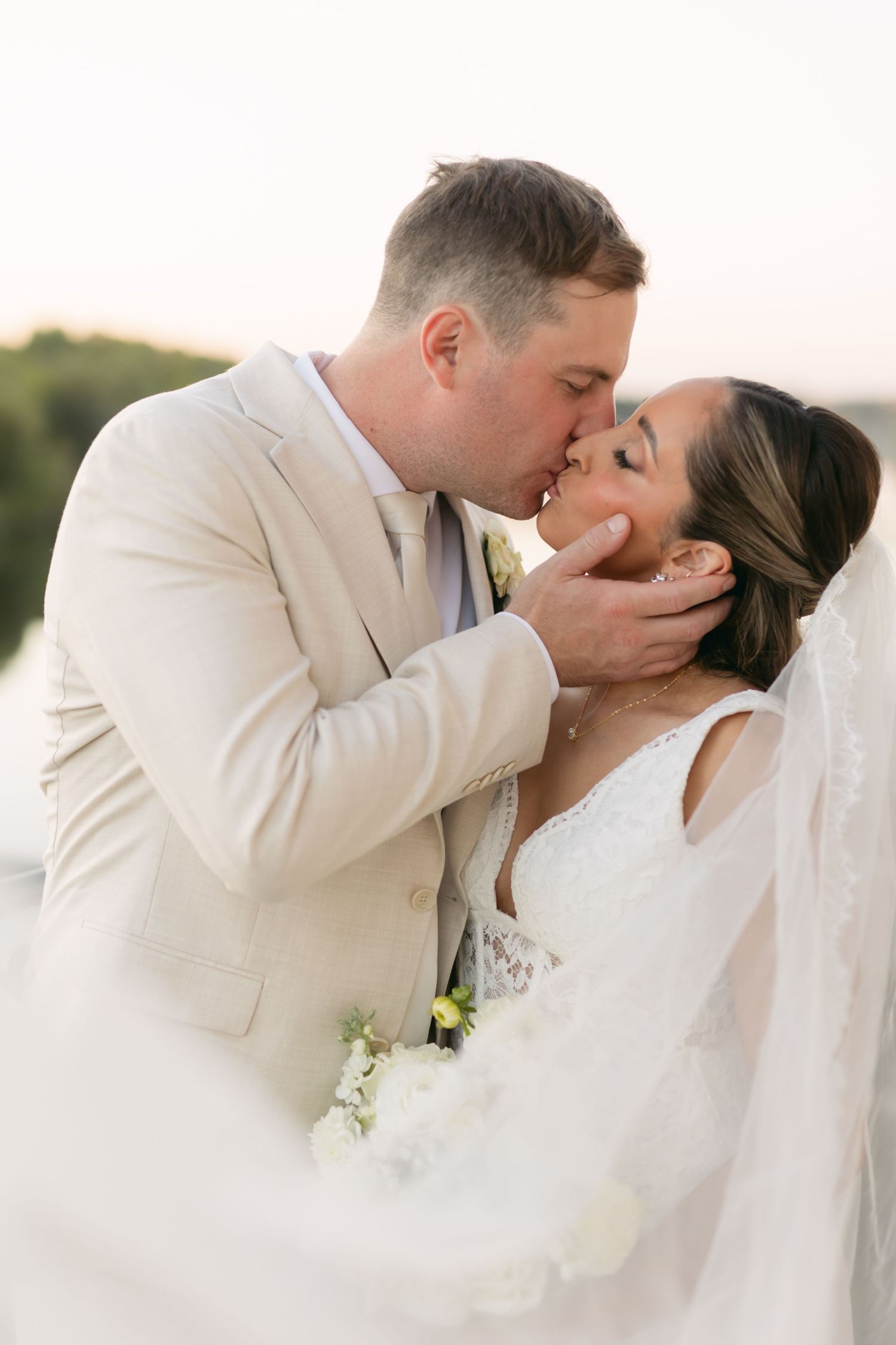A romantic sequence of wedding day kisses between newlyweds against a soft outdoor background.