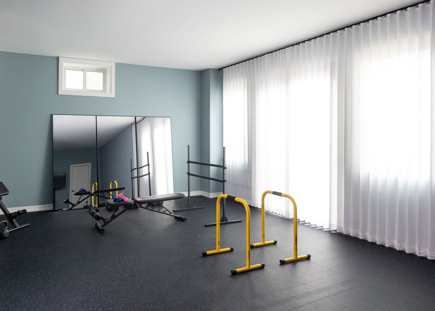 Home gym space with exercise equipment and floor-to-ceiling windows.