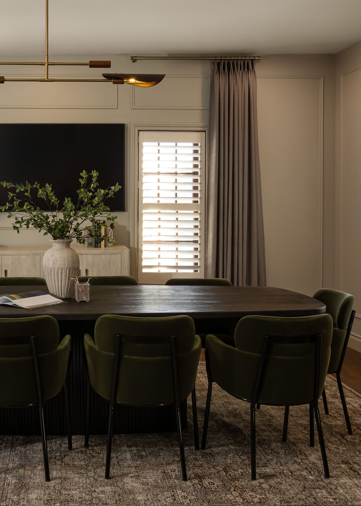 Contemporary dining room with dark velvet chairs and modern pendant lighting.