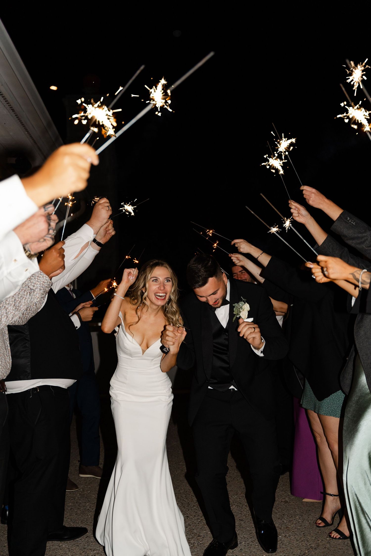 Wedding guests and newlyweds create magical moments with sparklers during evening celebrations.