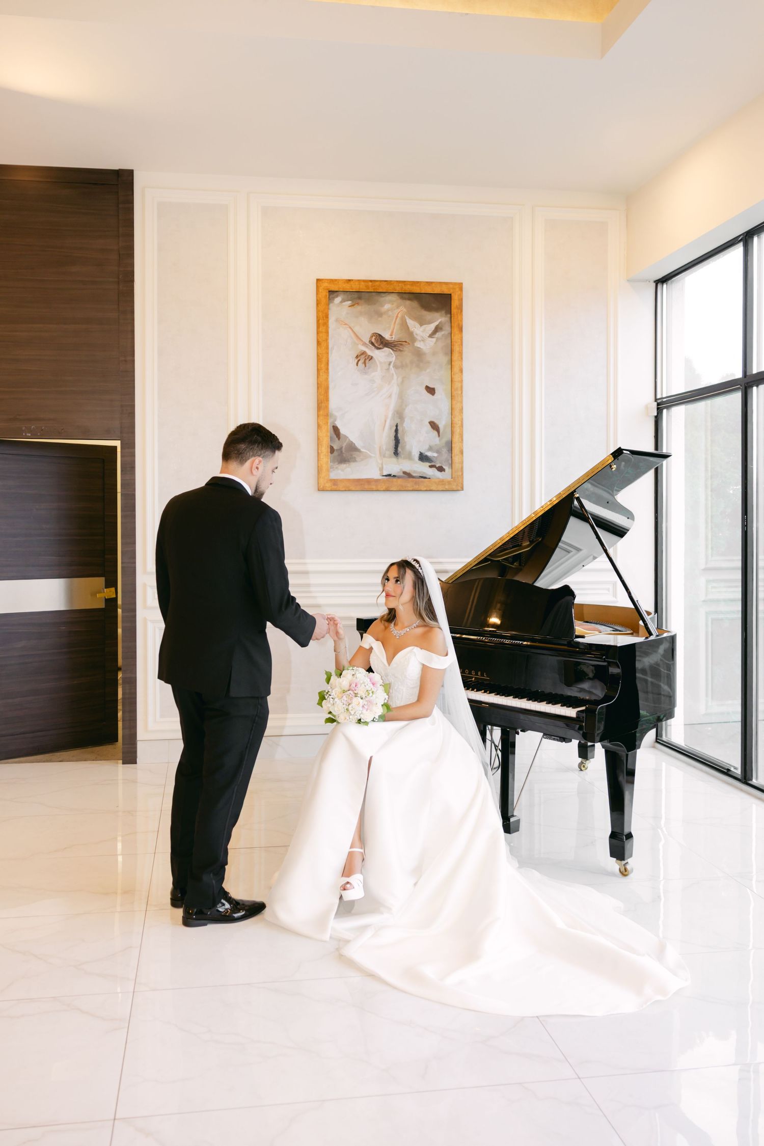 Elegant wedding photo session in a bright white room with a grand piano and floor-to-ceiling windows.