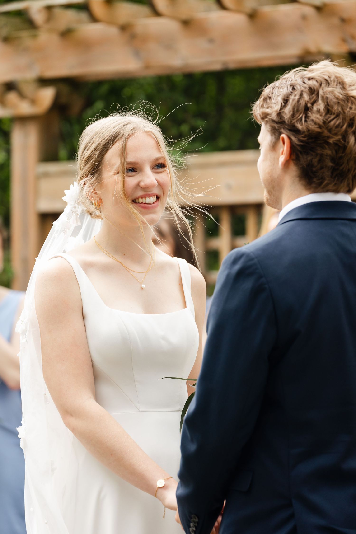 A candid moment of joy shared between newlyweds during their outdoor ceremony.