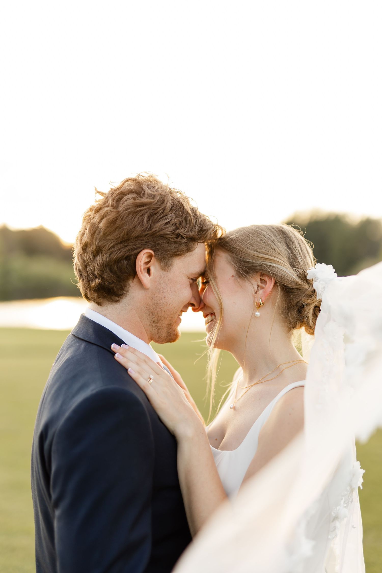 A close-up wedding portrait shows an intimate moment between the couple in golden sunlight.
