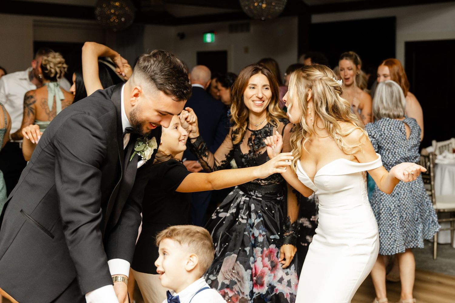 Lively wedding reception with guests dancing and celebrating on the dance floor.
